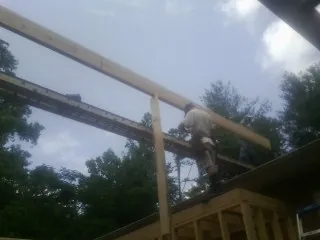 Carpenter setting a ridge beam over a new addition frame — Ice Dam Removal by Roofing Brothers in Somis